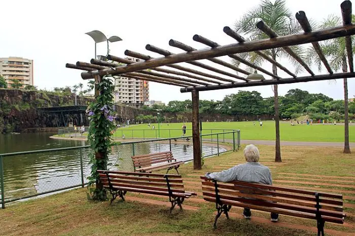 Pérgola, bancos e lago em área de descanso do Parque Raya